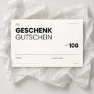 Inoiv Geschenkgutschein über CHF 100 auf weissem Seidenpapier