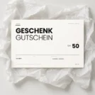 Inoiv Geschenkgutschein über CHF 50 auf weissem Seidenpapier